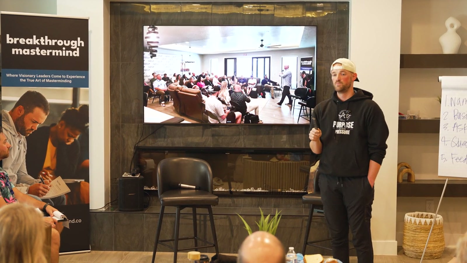 Braydon speaking beside a whiteboard at Breakthrough Mastermind